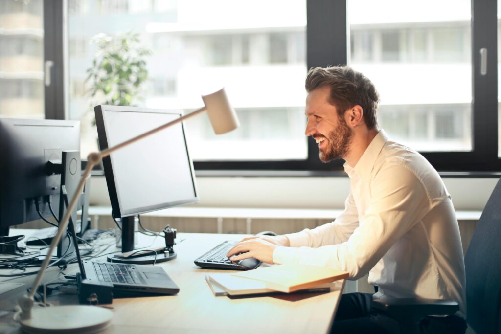 A sales outreach professional sitting at his desk.